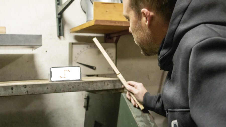 Arbeiten mit Zollstock und Mobiltelefon