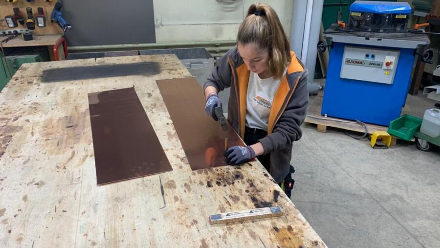 Junge Spenglerin beim Körnern, Spenglerei Schnyder AG